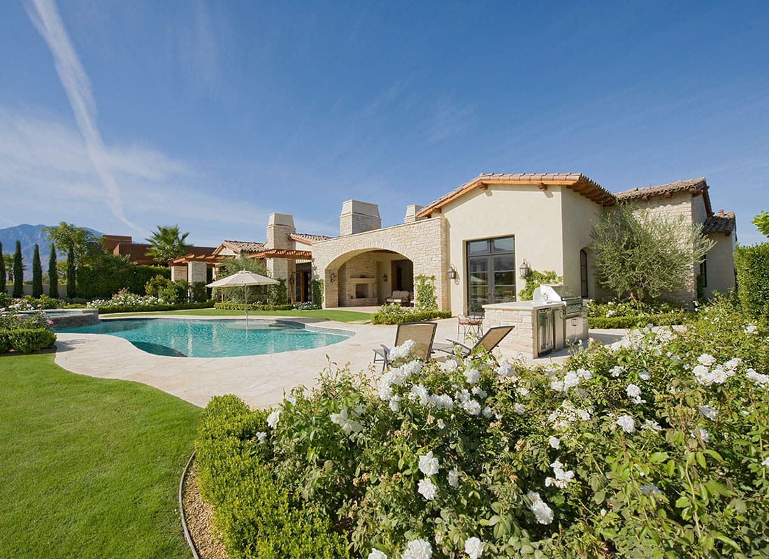 Personal Insurance - Scenic View of a One Story Home in California with a Pool and a Landscaped Backyard on a Sunny Day